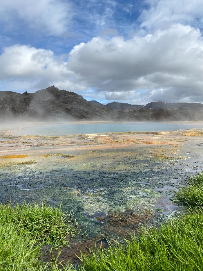 Blue water and colourful ground in a geothermal area in Iceland