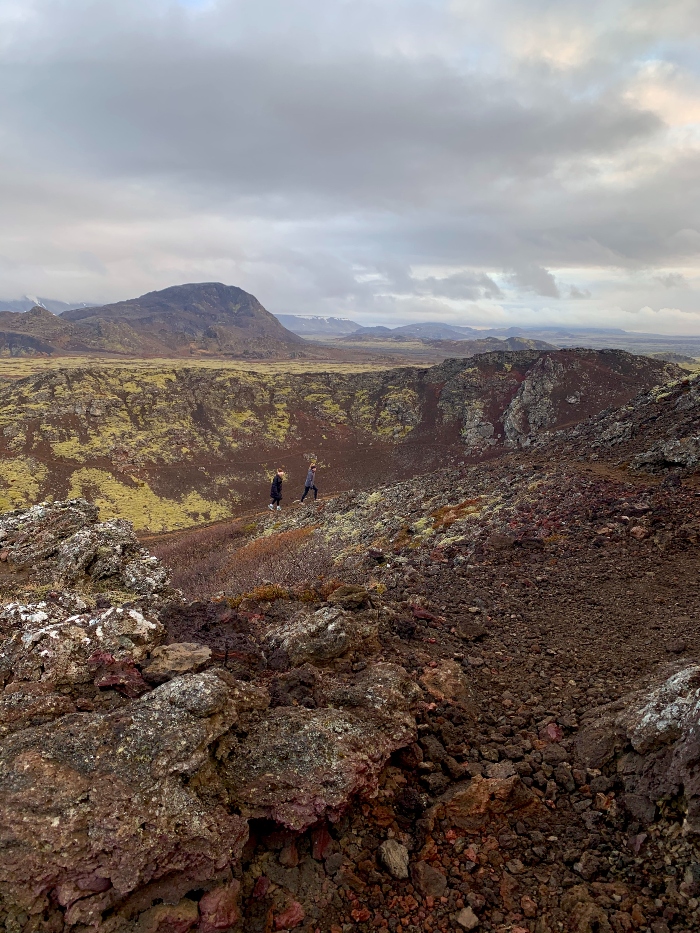 Two hikers climbing the colourful volcanic crater of Burfell close to Reykjavik Iceland