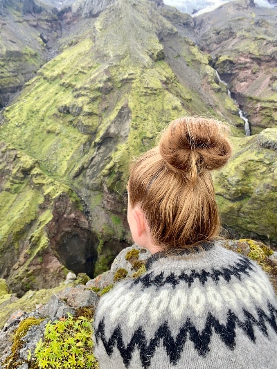 A hiker in Icelandic wool sweater admiring the view of a beautiful canyon