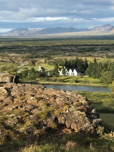Watching over Þingvellir National Park with lava rocks in the foreground and mountains in the background