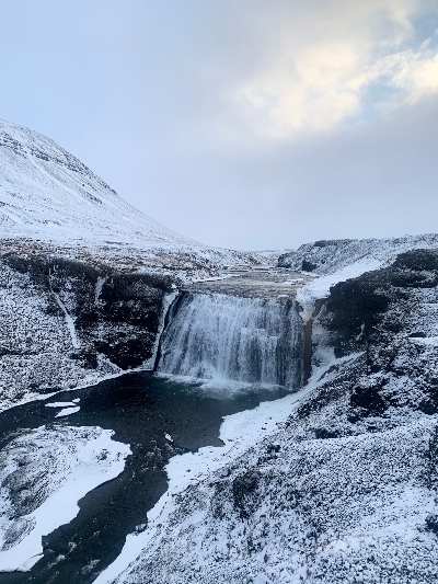 Waterfall in winter with snowy ground all around