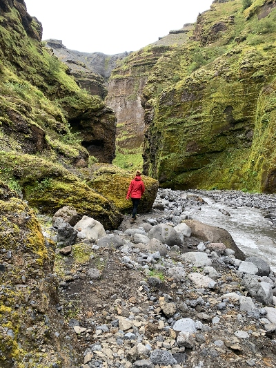 A hiker walking into the more narrow part of Stakkholtsgjá Canyon in Iceland