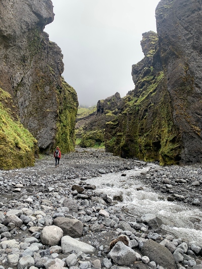 A hiker walking along a river in Stakkholtsgjá Canyon close to Thorsmork