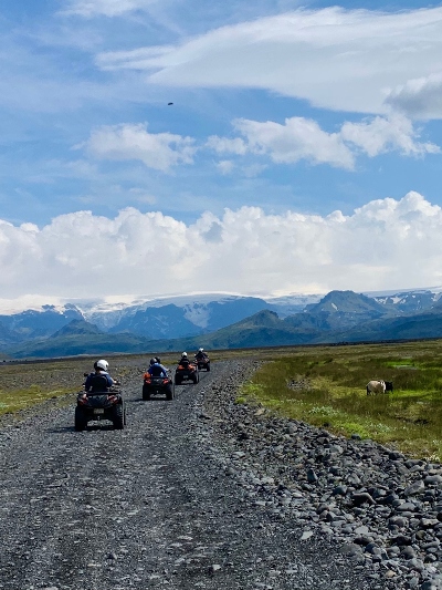 A few ATVs driving towards blue mountains in beautiful summer weather in Iceland