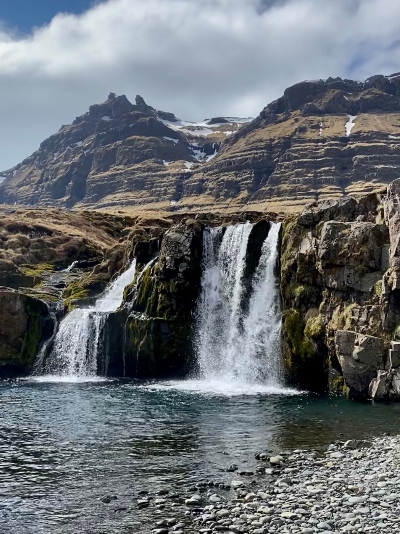 A small waterfall with a stunning mountain backdrop on Snæfellsnes Peninsula in Iceland