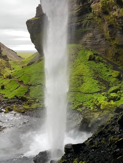 The view of a small waterfall in Iceland from behind 