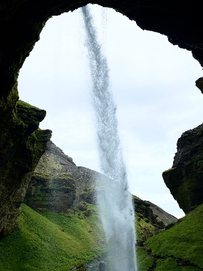 The view of a small waterfall from behind it