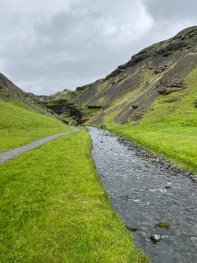 A trail along a small creek leading to a small but beautiful waterfall in Iceland