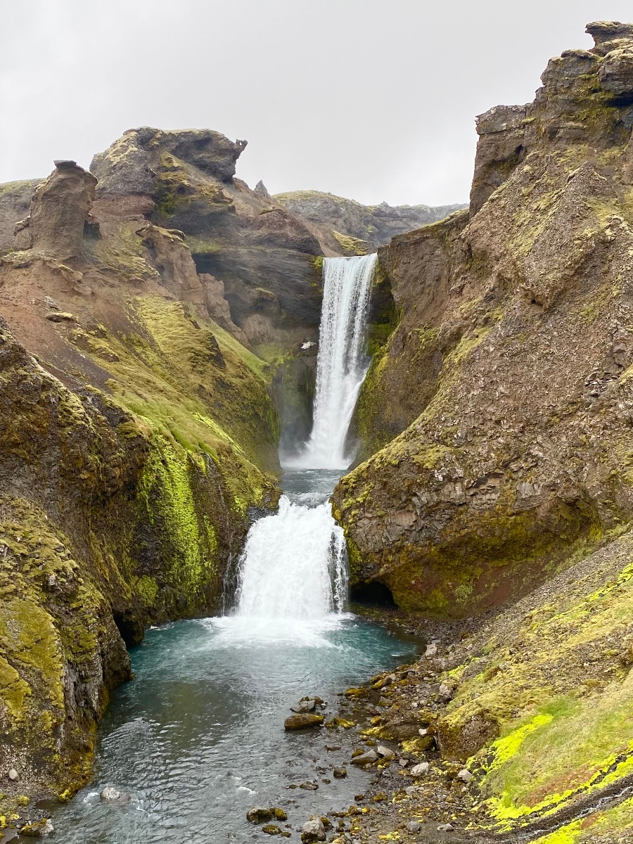 A double waterfall surrounded by brown cliffs on the Skógafoss Waterfall Hike in Iceland