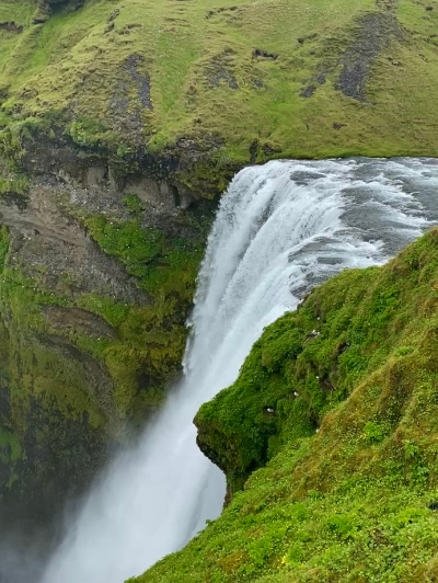 Skógafoss Waterfall seen from above where it falls from the cliff edge