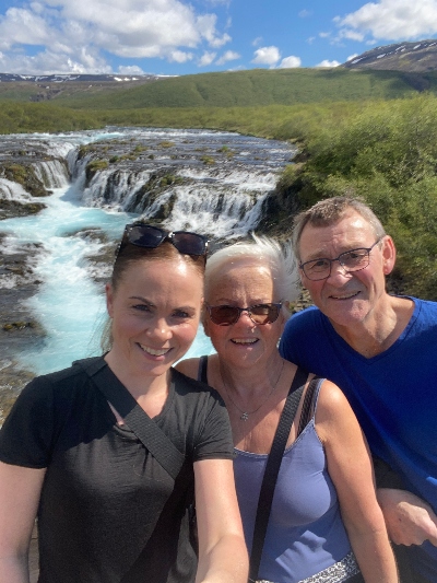 Happy hikers in front of Brúarfoss Waterfall in Iceland