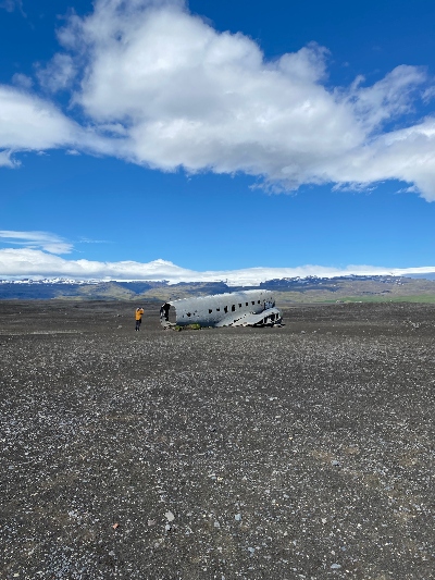 The plane wreckage on Sólheimasandur seen from afar with mountains in the background