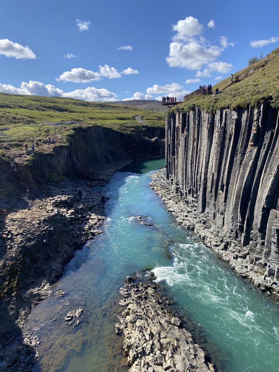 People standing on a viewing platform overlooking Stuðlagil Canyon