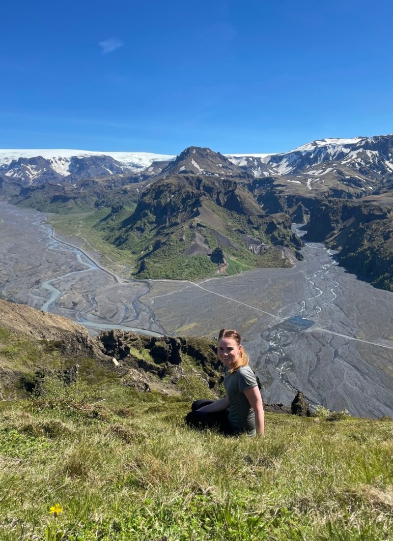 A happy hiker on top of Valahnúkur in Þórsmörk Iceland with stunning views behind herself