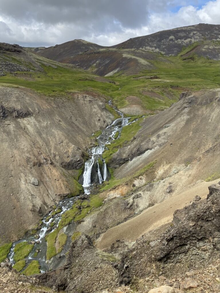 A beautiful view of a small waterfall on the trail to Reykjadalur Hot Springs in Iceland