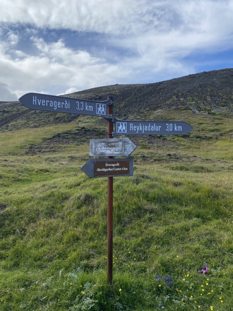 Signs at the trailhead to Reykjadalur Hot Springs showing how long the hike is