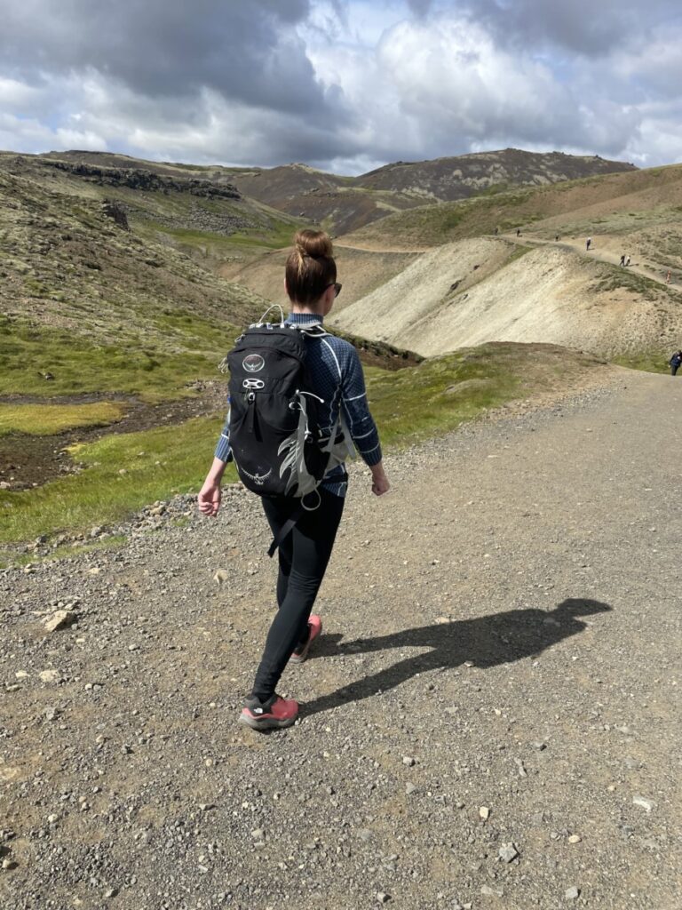 A woman hiking with her backpack on the trail to Reykjadalur Hot Springs