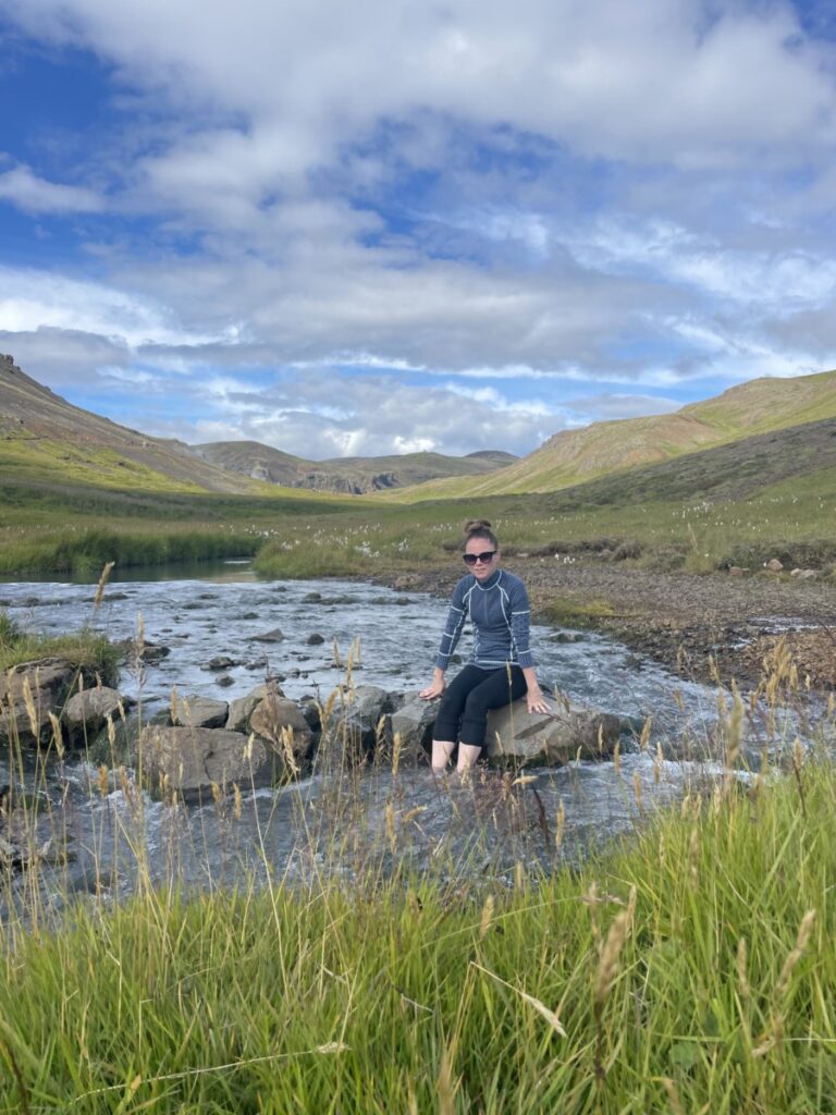 A woman taking a foot bath in the warm river in Reykjadalur Valley in Iceland