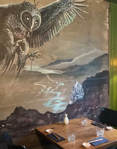 A painting of an owl on the wall in a sushi restaurant in Seyðisfjörður Iceland