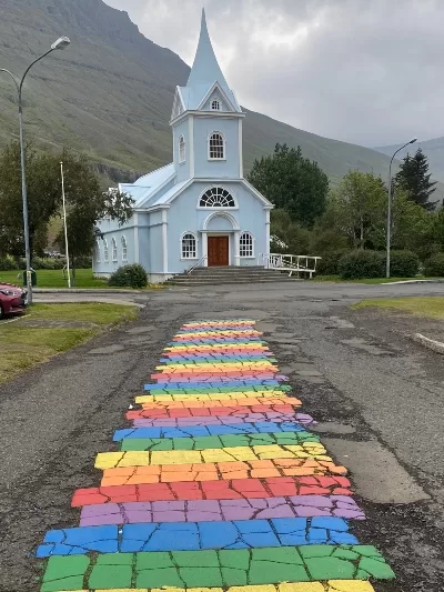 The blue church and rainbow street in Seyðisfjörður Iceland