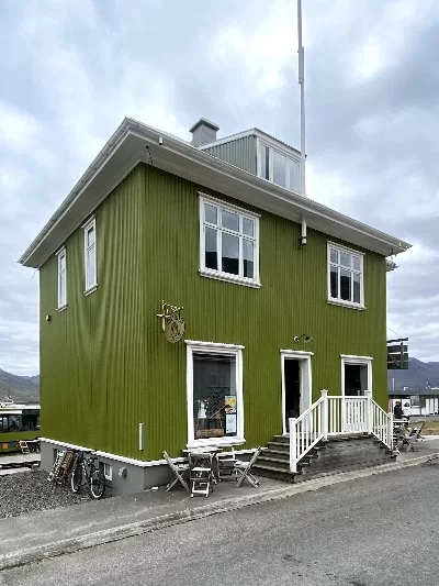 Big green timberhouse called Simbahöllin in Þingeyri that has been renovated.