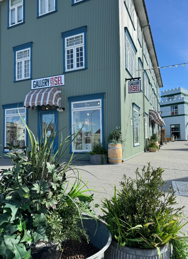 A green old timber house with white windows in the town center in Selfoss Iceland.